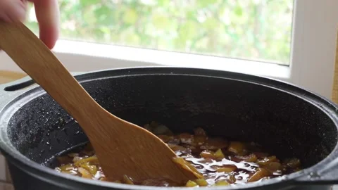 Stir the brew. Boil the fruit jam in a pot. Fruit preservation. Pieces of fruit Stock Footage 165346557