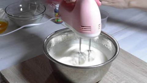 Stir the cake dough using a mixer in a metal bowl Stock Footage 236849800