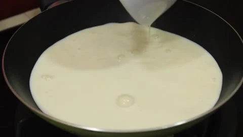 Stir the coconut milk in the pan. Someone cooks coconut milk Stock Footage 334647576