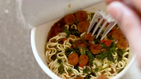 Stir the cooked cup noodles until mixed with the spices Stock Footage 253762514