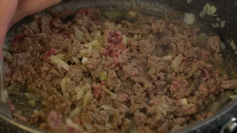 Stir cooking ground hash brown beef dropped on top of diced onion in in gray Stockbeeldmateriaal 266782831