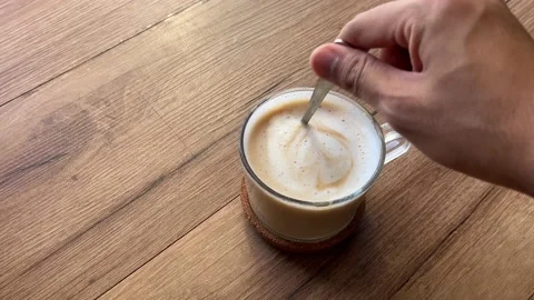 Stir a cup of coffee with a small spoon Stock Footage 169211057