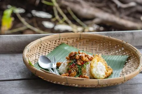 Stir fried basil leaf Chicken with rice and put Fried egg in Bamboo Basket on Stock Photos