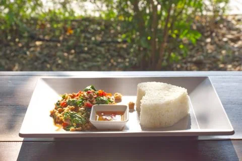 Stir fried basil leaf pork with rice  on wooden table. Stock Photos