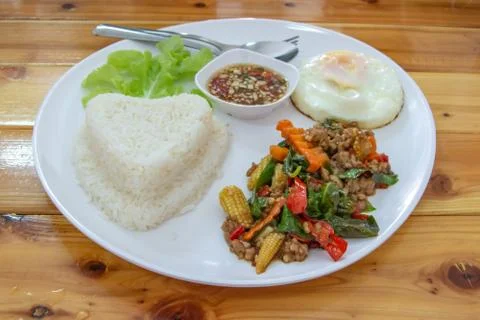 Stir fried basil leaf pork with rice and put the preserved egg. Stock Photos