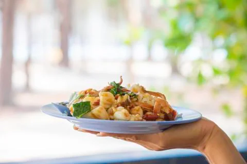 Stir fried basil leaf Shrimp and squid with rice on the plate in hand. Stock Photos
