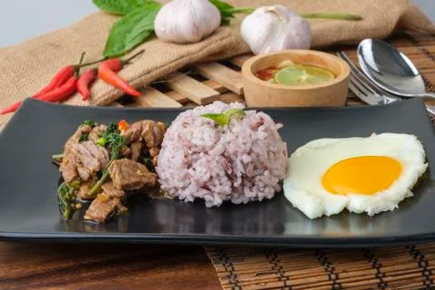 Stir-fried beef basil with fried egg and riceberry rice. Stock Photos