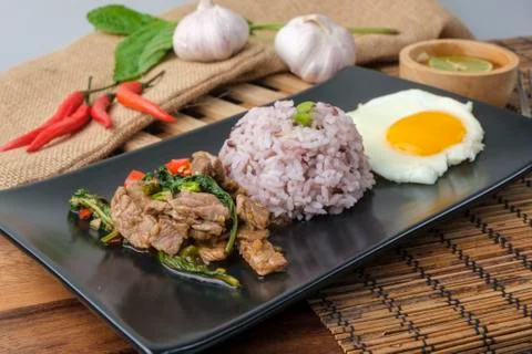 Stir-fried beef basil with fried egg and riceberry rice. Stock Photos