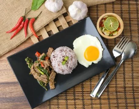 Stir-fried beef basil with fried egg and riceberry rice. Stock Photos