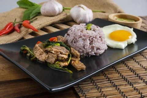 Stir-fried beef basil with fried egg and riceberry rice. Stock Photos