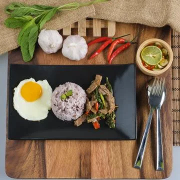 Stir-fried beef basil with fried egg and riceberry rice. Stock Photos