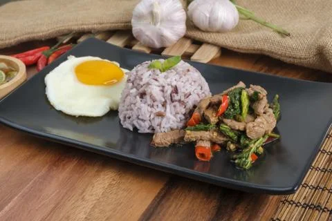 Stir-fried beef basil with fried egg and riceberry rice. Stock Photos