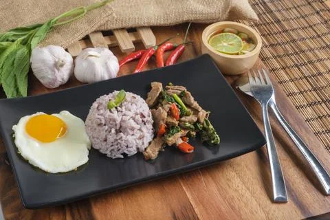 Stir-fried beef basil with fried egg and riceberry rice. Stock Photos