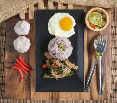 Stir-fried beef basil with fried egg and riceberry rice. Stock Photos