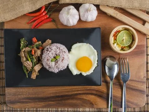 Stir-fried beef basil with fried egg and riceberry rice. Stock Photos