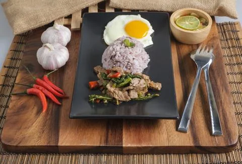 Stir-fried beef basil with fried egg and riceberry rice. Stock Photos
