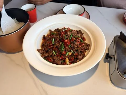 Stir-fried beef with red and green peppers on a white plate. Stock Photos