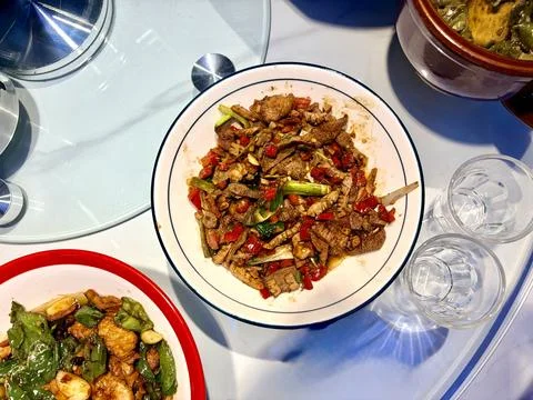Stir-fried beef with red and green peppers on a round plate. 스톡 사진