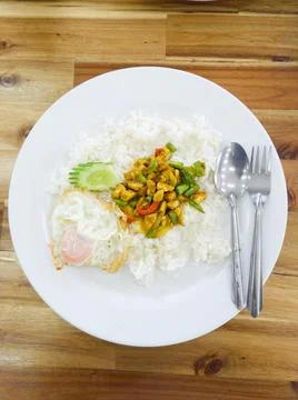 Stir fried chicken curry paste with lentils over rice and cucumber and fried Stock Photos