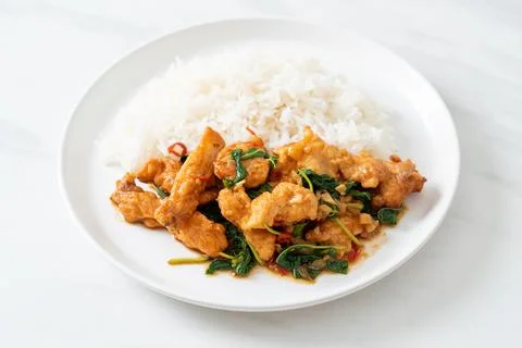 Stir-fried fried fish with basil and chili in thai style topped on rice Stock Photos