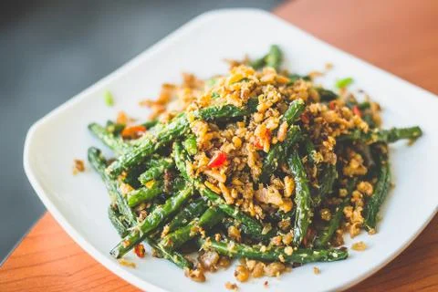 Stir fried long beans with chilli and salted fish served on a  white plate Stock Photos
