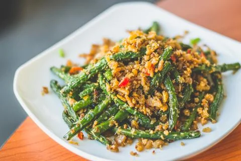 Stir fried long beans with chilli and salted fish served on a  white plate Stock Photos