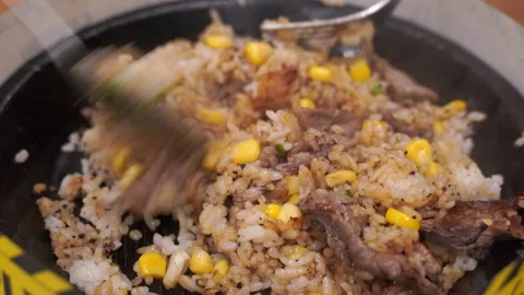 Stir-fried rice with beef and corn spring onions served in a hot pan. Japanes Stock Footage 131657952