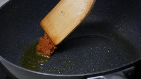 Stir fried the spices , curry paste  , food palm oil  together in the black t Stock Footage 89490917