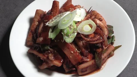 Stir-fried spicy squid on a white plate. Stock Footage 293748545