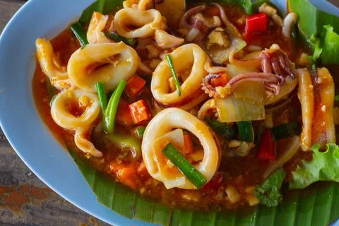 Stir Fried Squid with Salted Egg on wood table close up . Stock Photos