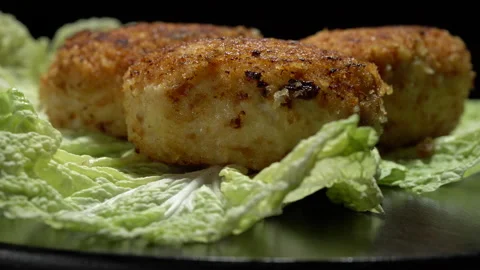 Stir-fried turkey cutlets on lettuce leaves on a black background. Video stock 154560101
