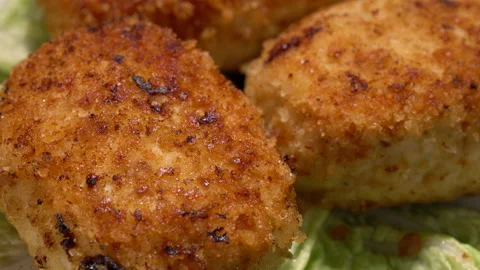 Stir-fried turkey cutlets on lettuce leaves on a black background. Stock Footage 154560436