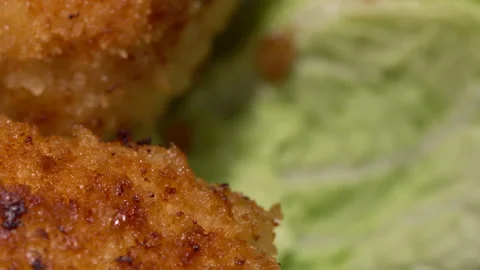 Stir-fried turkey cutlets on lettuce leaves on a black background. Stock Footage 154745870
