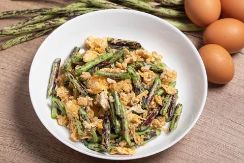 Stir fried Yardlong bean with eggs on wooden background Stock Photos