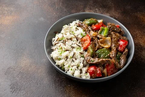 Stir fry Chinese pepper beef steak with onion, red and green bell pepper, rice Stock Photos