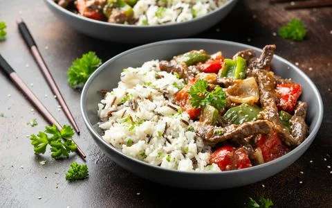 Stir fry Chinese pepper beef steak with onion, red and green bell pepper, rice Stock Photos