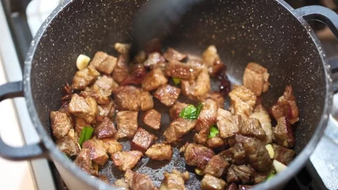 Stir-Frying Beef Cubes with Garlic in a Non-Stick Pan Stock Footage 315743449