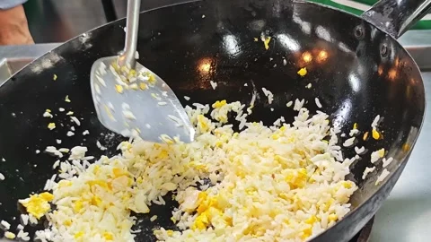 Stir-frying egg fried rice in a black iron wok. Stock Footage 342393527