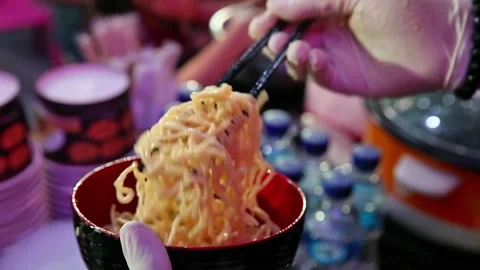 Stir the noodles using chopsticks while stirring Stock Footage 267681548