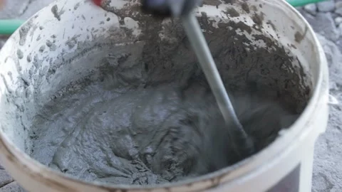 Stir the plaster in a bucket with a mixer Stock Footage 219116723