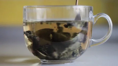 Stir with a spoon leaves a Cup of tea Stock Footage 73791385