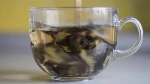 Stir with a spoon leaves a Cup of tea Stock Footage 73791398