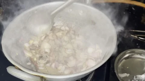 Stiring the ginger garlic paste with fried onion and curry leaves Video stock 312321890