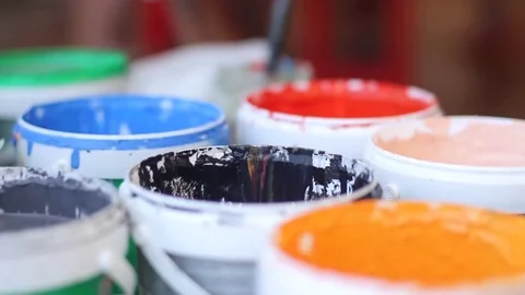 Stirring and application of paint on the paintbrush. Stockbeeldmateriaal 75075508
