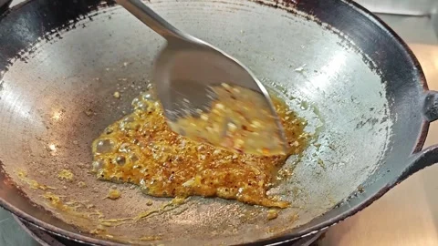 Stirring and cooking thick palm sugar sauce in a wok close up. Stock Footage 339185125
