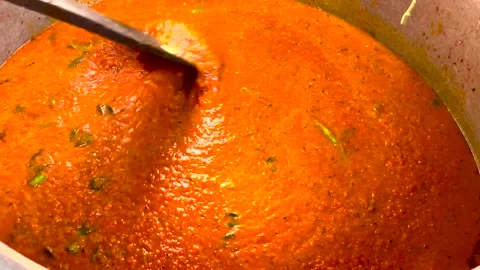 Stirring the big batch of mixed vegetable curry and adding spices. Stock Footage 167244998