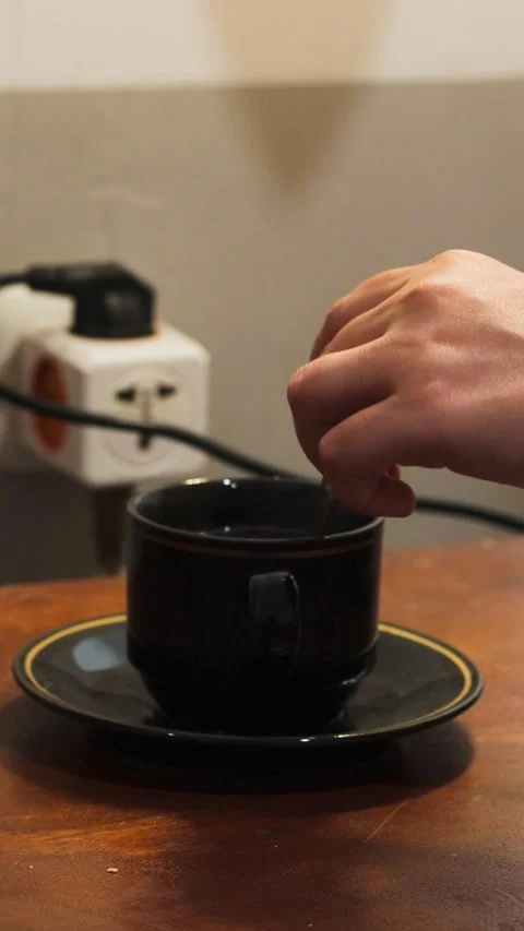 Stirring black coffee in a cup with a spoon Stock Footage 342587123