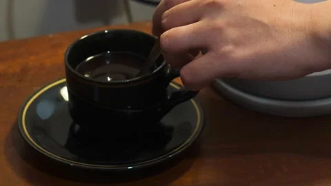 Stirring black coffee in a cup with a spoon Stock Footage 342587147
