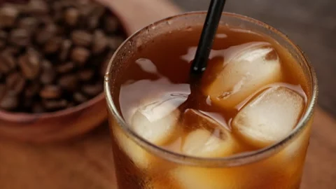 Stirring black coffee with ice. Making iced coffee Video stock 243079191