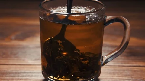 Stirring black hot tea with a spoon, slow motion. Stock Footage 84567736